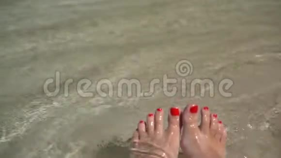 女人的双腿带着踏板躺在沙滩上海浪和白沙视频的预览图