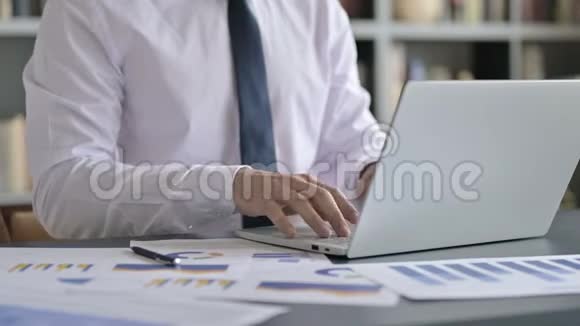 办公桌上使用笔记本电脑的商人特写镜头视频的预览图