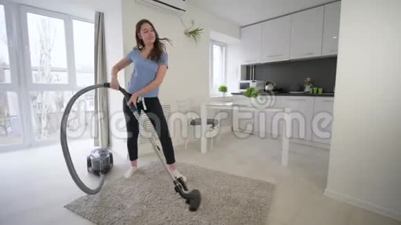 有趣的女管家在家里打扫吸尘器在房间里跳舞唱歌视频的预览图