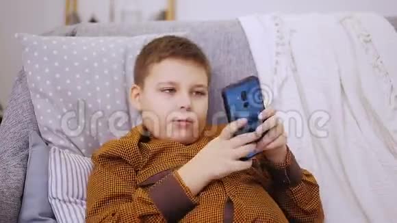胖男孩在智能手机上玩视频的预览图