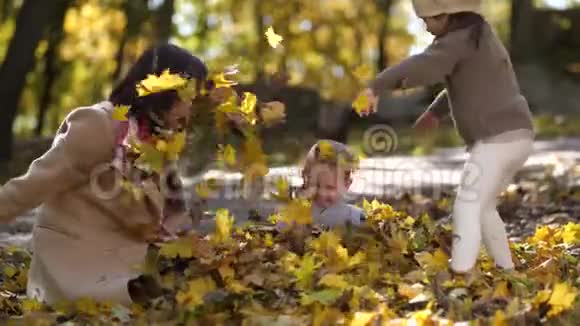 快乐的妈妈和特别的女孩一起扔树叶视频的预览图