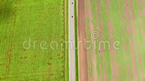垂直飞越公路上方空中飞过了两边绿油油的田野飞越上空视频的预览图