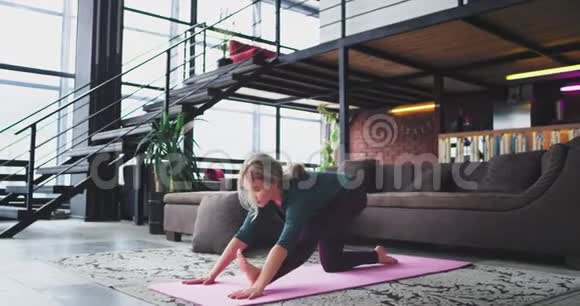 早上做瑜伽运动年轻女士练习瑜伽伸展身体以获得一整天的能量视频的预览图