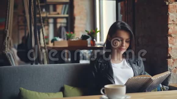 美丽的年轻女士在咖啡馆看书享受文学和孤独视频的预览图