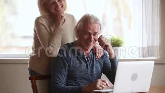 快乐的老夫妇笑着说一起用笔记本电脑视频的预览图