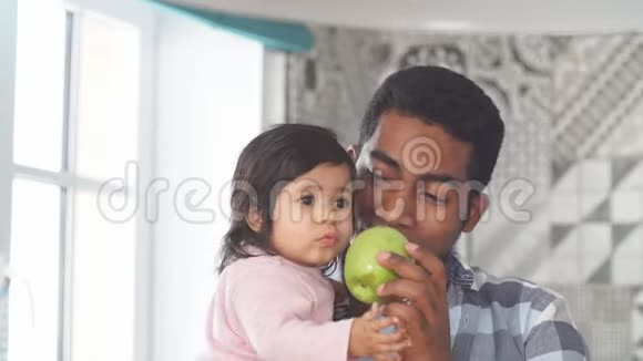 一位非洲英俊的父亲给他的小女孩送绿苹果视频的预览图