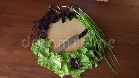 新鲜的蔬菜和草药摆在一个圆形的切割板上刀在桌子上视频的预览图