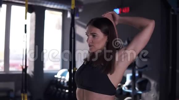 年轻的健身女子在健身房训练女运动员在锻炼前伸展身体和双手女性锻炼者视频的预览图
