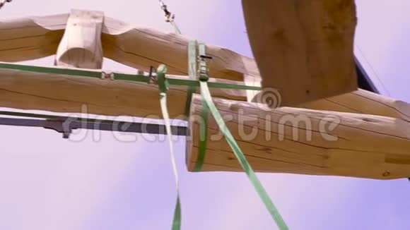 房屋在建木梁正由吊车升起剪辑木屋屋顶细节原木底部视图视频的预览图