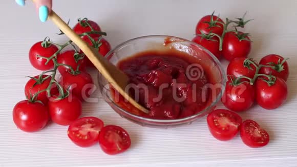 一个女人的特写把一个木勺放在番茄酱的白色背景上视频的预览图