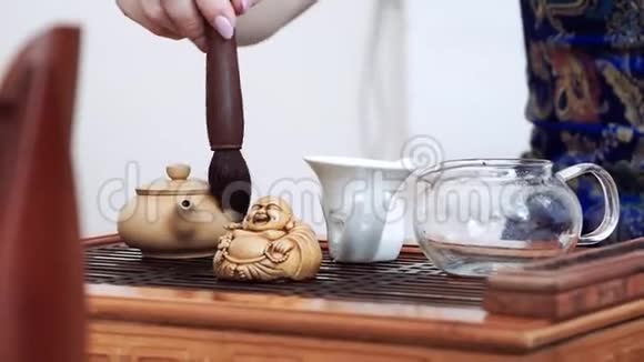 餐桌上的中国茶道杯子水壶筛子刷子和雕像视频的预览图