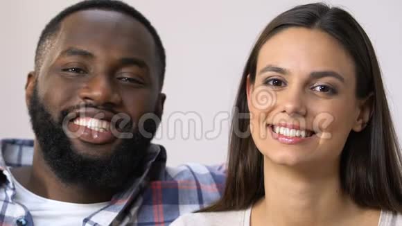 迷人的混血家庭夫妇真诚地微笑着进入镜头关系视频的预览图