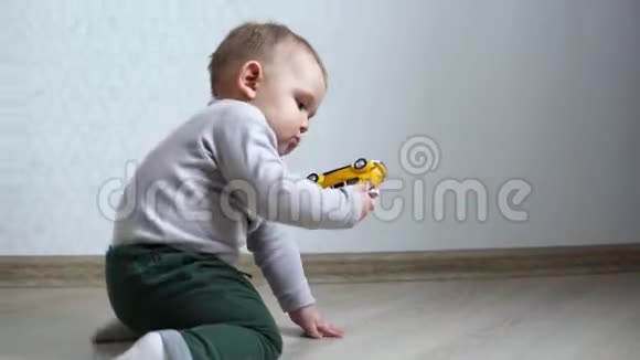 小可爱的宝宝从地板上捡起一辆玩具车研究它视频的预览图