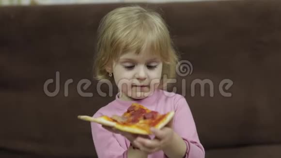 可爱的高加索女孩吃披萨饥饿的孩子吃披萨视频的预览图