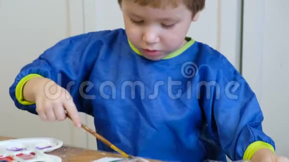 可爱的4岁金发男孩用水粉画画视频的预览图