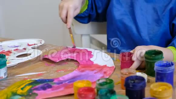 可爱的4岁金发男孩用水粉画画视频的预览图