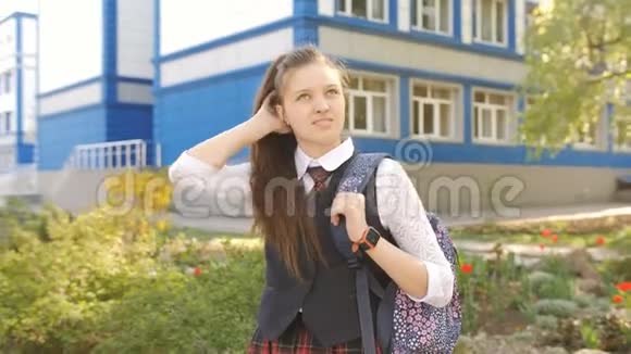 学校附近一个带背包的女学生的肖像少女直发站在附近视频的预览图