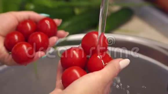 在专业的厨房里用自来水清洗西红柿特写镜头视频的预览图