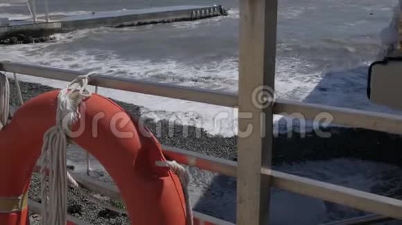 海上风暴巨浪撞击混凝土码头篱笆上挂着一条生命线视频的预览图