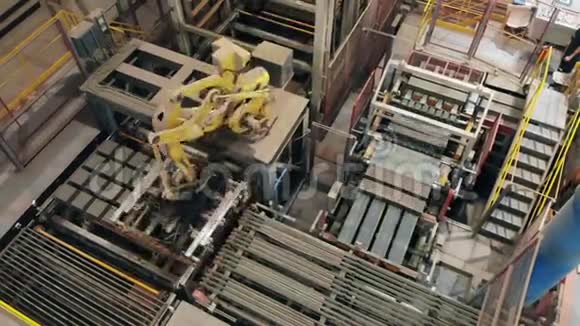 现代工厂设备机械臂将砖块放置在设备的皮带上视频的预览图