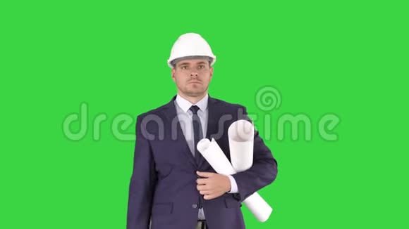 男建筑师穿着西装戴着安全帽带着蓝图和公文包走在绿色屏幕上铬钥匙视频的预览图