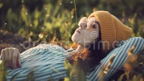 女孩躺在公园里的草坪上夏日的春日视频的预览图