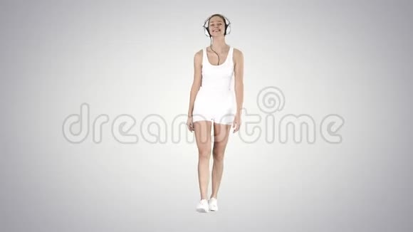 迷人的健身女孩散步和听音乐梯度背景视频的预览图