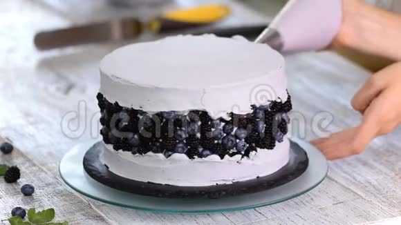 为生日聚会或婚礼做紫色蛋糕的女人视频的预览图