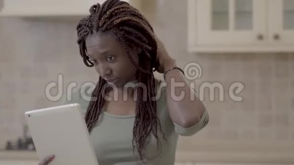 一位留着长发的美籍非洲裔美女脱掉头发上的橡胶准备在视频的预览图