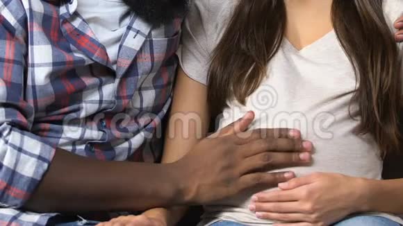 未来的父亲温柔地抚摸怀孕女友的肚子计划生育视频的预览图