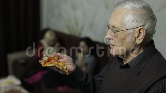 戴眼镜的漂亮老人吃披萨他的家庭背景视频的预览图