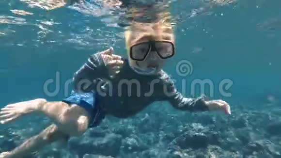 的孩子欢迎你和他一起在清澈的蓝色海水中潜水视频的预览图