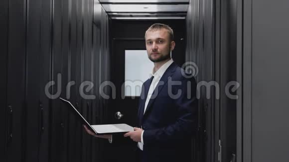 IT工程师在数据中心服务器机房用笔记本电脑进行人脸画像视频的预览图