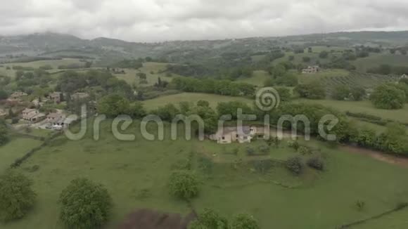鸟瞰漫步在乡村和绿色山谷与树林和山丘视频的预览图