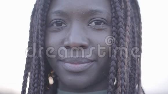 在天空和街道的背景下特写自信的非裔美国年轻黑人微笑的女人的肖像视频的预览图