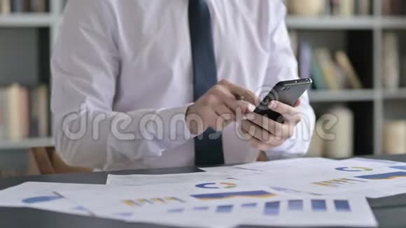 在办公桌上用手机近距离拍摄商人视频的预览图