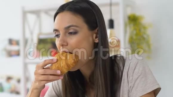 女孩咬牛角面包感到不愉快的疼痛牙齿和牙龈敏感视频的预览图