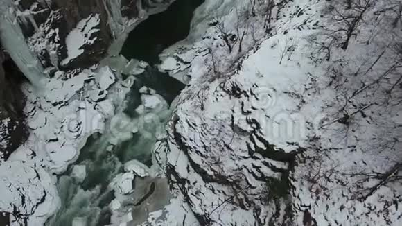 一条河和一条冰冻的瀑布降落到峡谷的地面视频的预览图