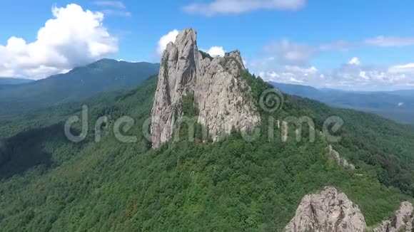 一块巨大的岩石露头对着蓝色多云的天空视频的预览图