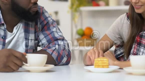 女孩用美味的蛋糕喂非洲裔美国男友情侣喝咖啡视频的预览图
