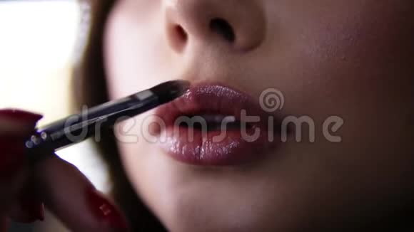 极接近镜头化妆师最后触摸与刷子上的嘴唇年轻女子程序应用程序视频的预览图