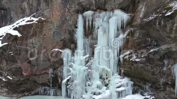 峡谷中陡峭的石壁上的冰冻瀑布视频的预览图