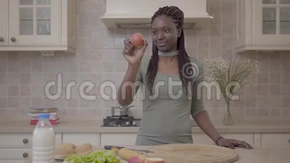 自信的非裔美国年轻微笑的女人准备馅饼微笑着看着苹果视频的预览图