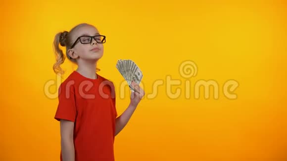 戴眼镜的有趣女孩用一大笔现金银行业务视频的预览图
