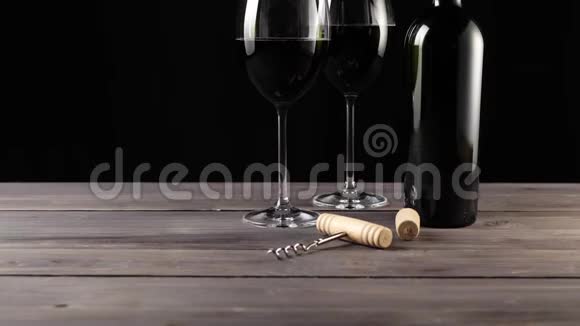 豪华红酒两个酒杯开瓶器软木塞和一瓶红酒由美味的红葡萄制成视频的预览图