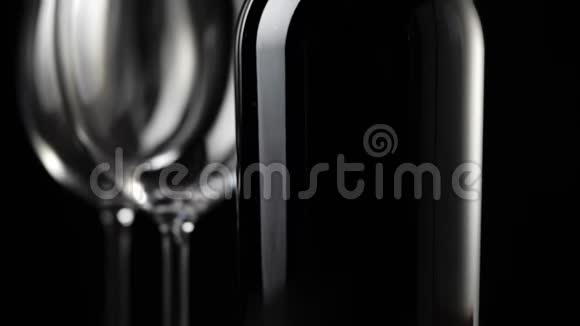 豪华红酒两个空酒杯和一瓶红酒由桌上美味的红葡萄和黑色制成视频的预览图