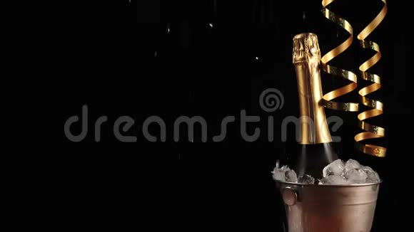 好香槟酒瓶子与起泡葡萄酒在一个桶与真正的冷冰在黑色背景金色丝带圣诞节视频的预览图