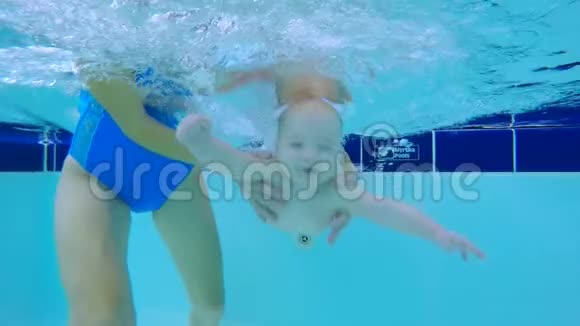 婴儿在妇女的帮助下在水下游泳视频的预览图