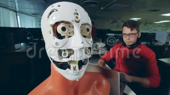 女专家正在调整一个机器人脸上人形面具视频的预览图