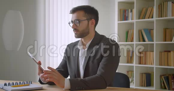 成人英俊的白种人商人在眼镜上的特写肖像使用平板电脑并显示绿色彩色屏幕到视频的预览图